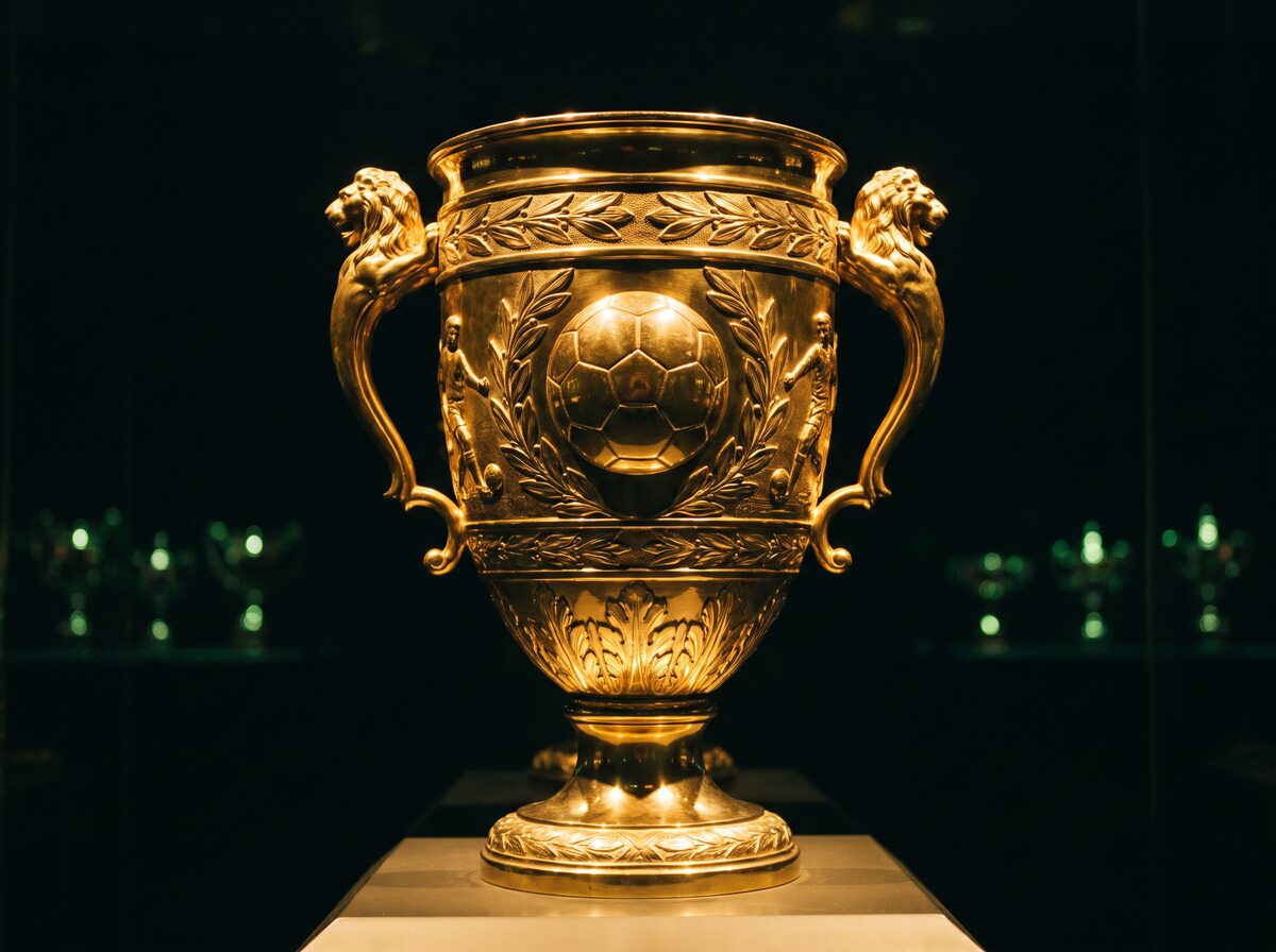 A golden trophy lit in a dark trophy room